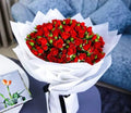 100 stems of red Baby Rose Grande Bouquet by Ward and Haneen, showcasing vibrant red roses arranged in a lush floral display.