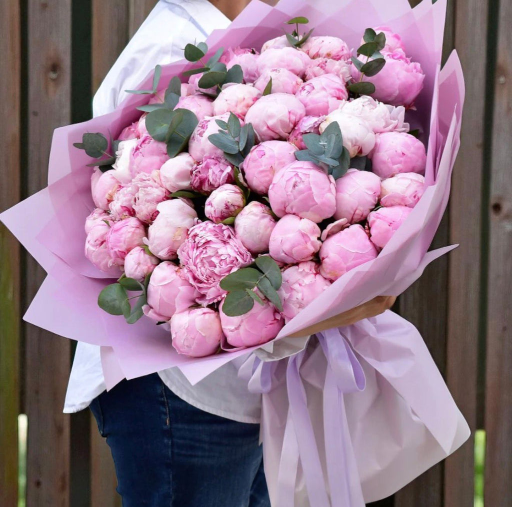 Bouquet of 50 pink peony flowers from Ward and Haneen arranged in a large floral display.