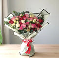Mixed Rose Elegance bouquet by Ward and Haneen featuring various pink and red roses arranged beautifully.