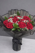 Elegant red rose bouquet featuring 12 roses from Ward and Haneen with lush green leaves and full bloom petals.