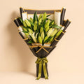 Ward and Haneen Lily Luxe Wrap draped over a chair, showcasing soft fabric and elegant design in a cozy indoor setting.