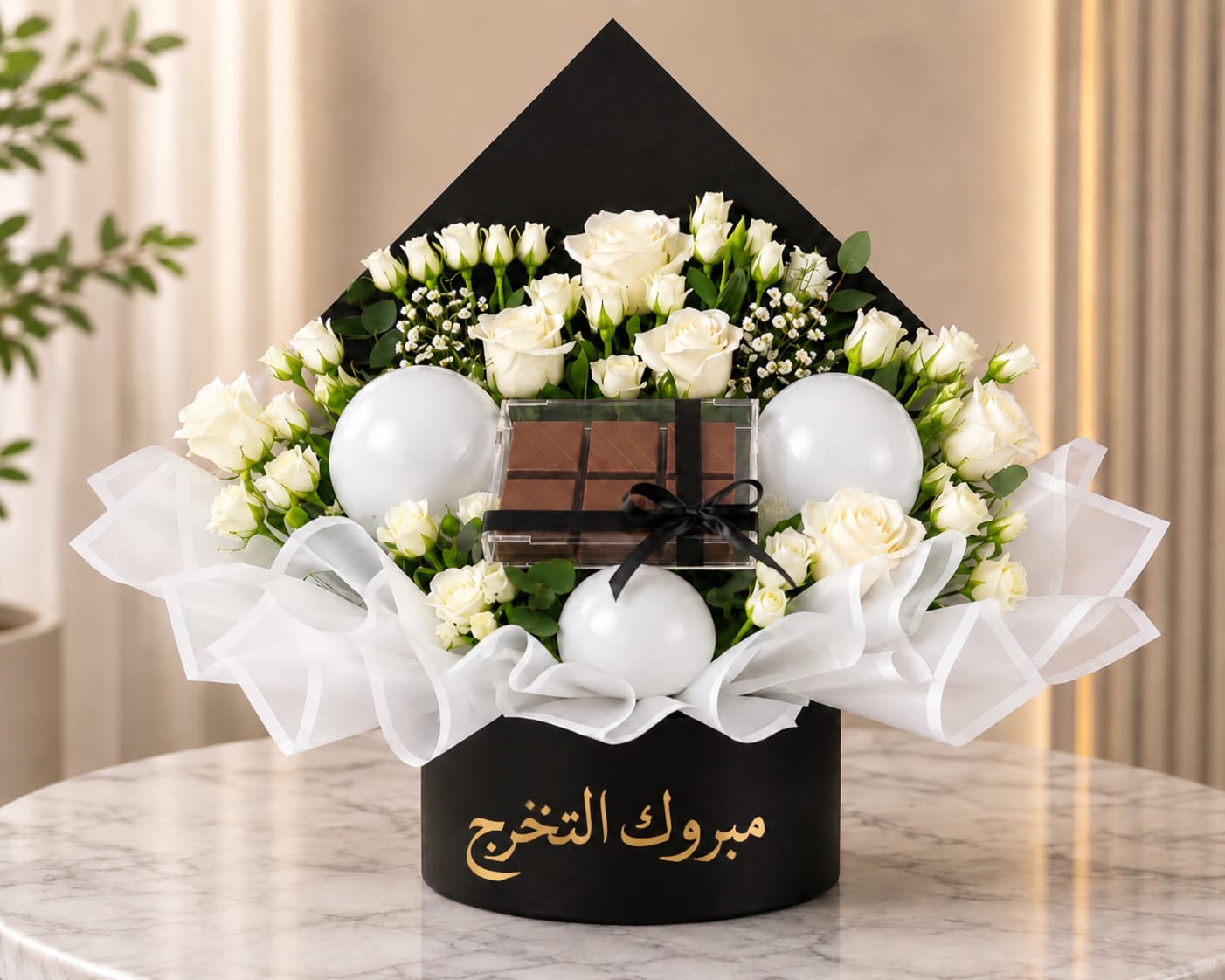 Graduation flower and chocolate gift box from Ward and Haneen with colorful flowers and assorted chocolates in a decorative box.