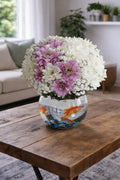 Pink and white chrysanthemum goldfish bowl by Ward and Haneen, featuring vibrant flowers in a clear glass fishbowl display.