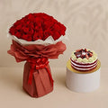 Bouquet of 50 red roses from Ward and Haneen alongside a strawberry cake on a white plate.