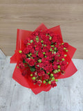 Red baby roses in elegant wrapping by Ward and Haneen, showcasing vibrant crimson blooms in a beautifully crafted bouquet.