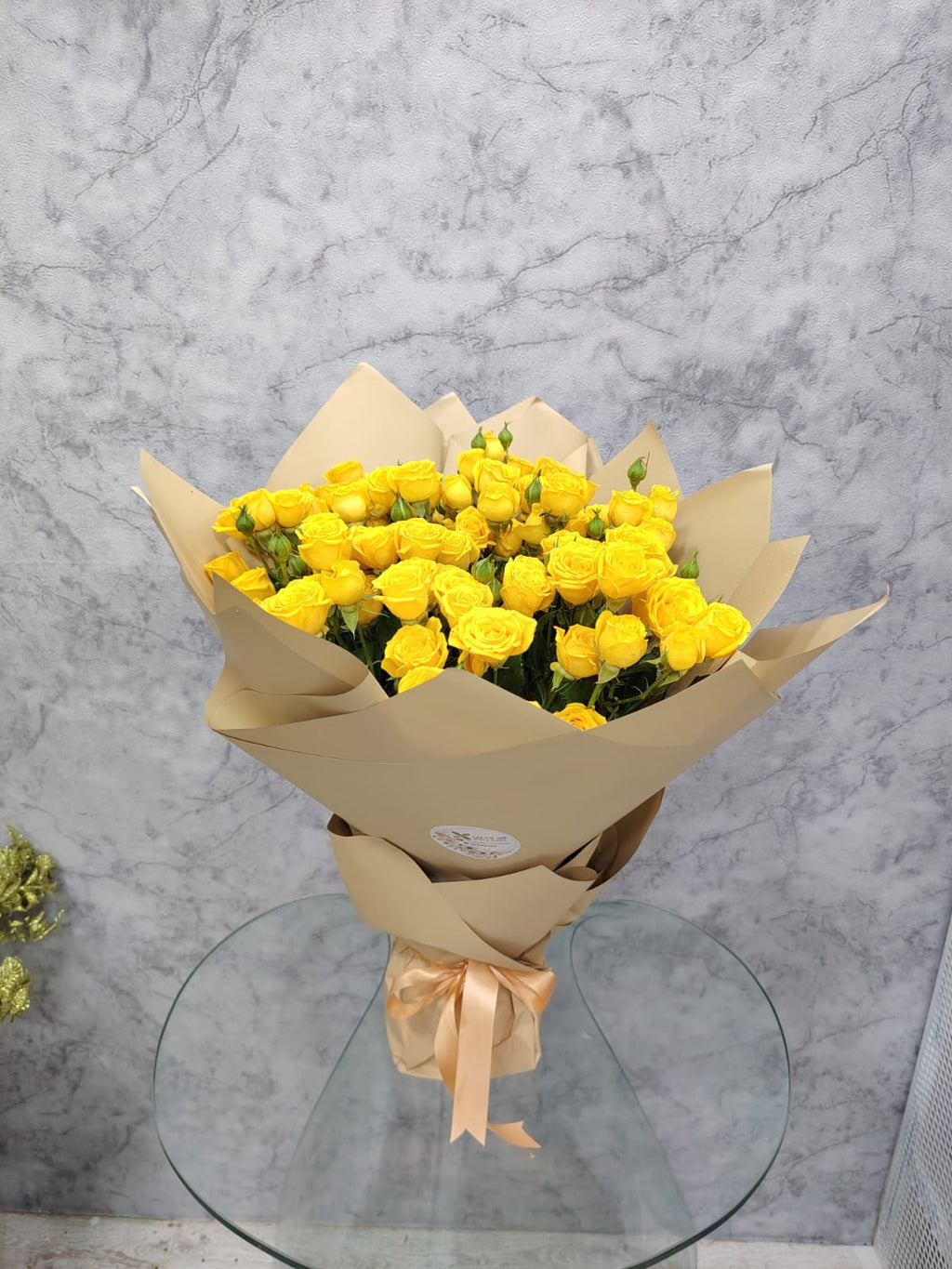 Crimson Deluxe 20 yellow baby roses from Ward and Haneen arranged in a bouquet with vibrant blooms and green foliage.