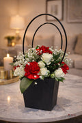 Red and white modern handle flower box by Ward and Haneen, featuring fresh mixed flowers arranged in a stylish container.