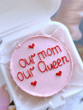 Pastel pink mini bento cake with "Our Mom Our Queen" inscription from Ward and Haneen, decorated with floral accents.