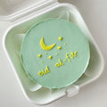 Eid al-Fitr bento cake from Ward and Haneen, decorated with festive designs and colorful icing, displayed on a plate.