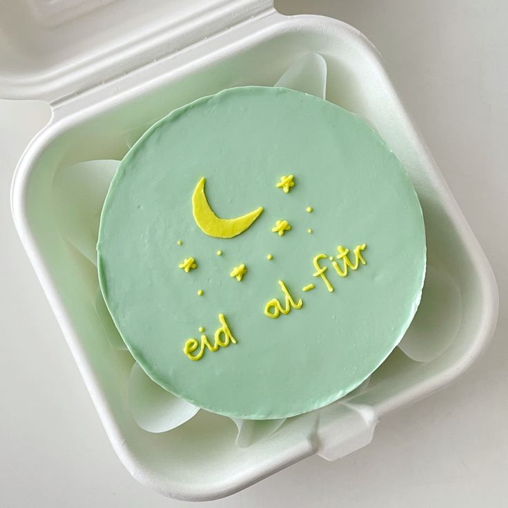 Eid al-Fitr bento cake from Ward and Haneen, decorated with festive designs and colorful icing, displayed on a plate.