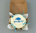 Blue ribbon graduation bento cake by Ward and Haneen with "You Did It!" decoration and colorful frosting, perfect for celebration.