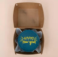 Mini bento cake with teal blue Happy New Year fireworks design by Ward and Haneen, featuring colorful festive decorations.