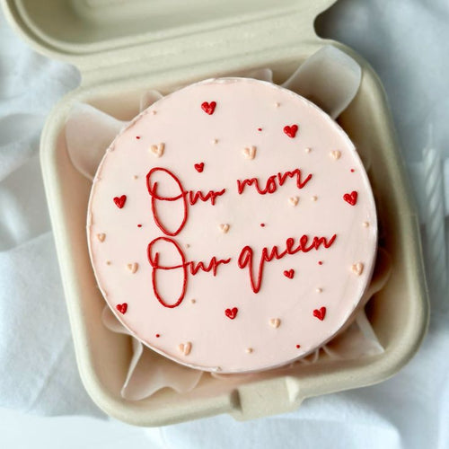 Mini Bento cake by Ward and Haneen featuring the "Our Mom, Our Queen" design, decorated with colorful frosting and edible decorations.