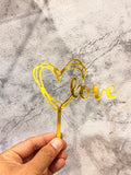 Gold Love Heart Cake Topper from Ward and Haneen, featuring a shiny metallic finish and elegant heart design for celebration cakes.