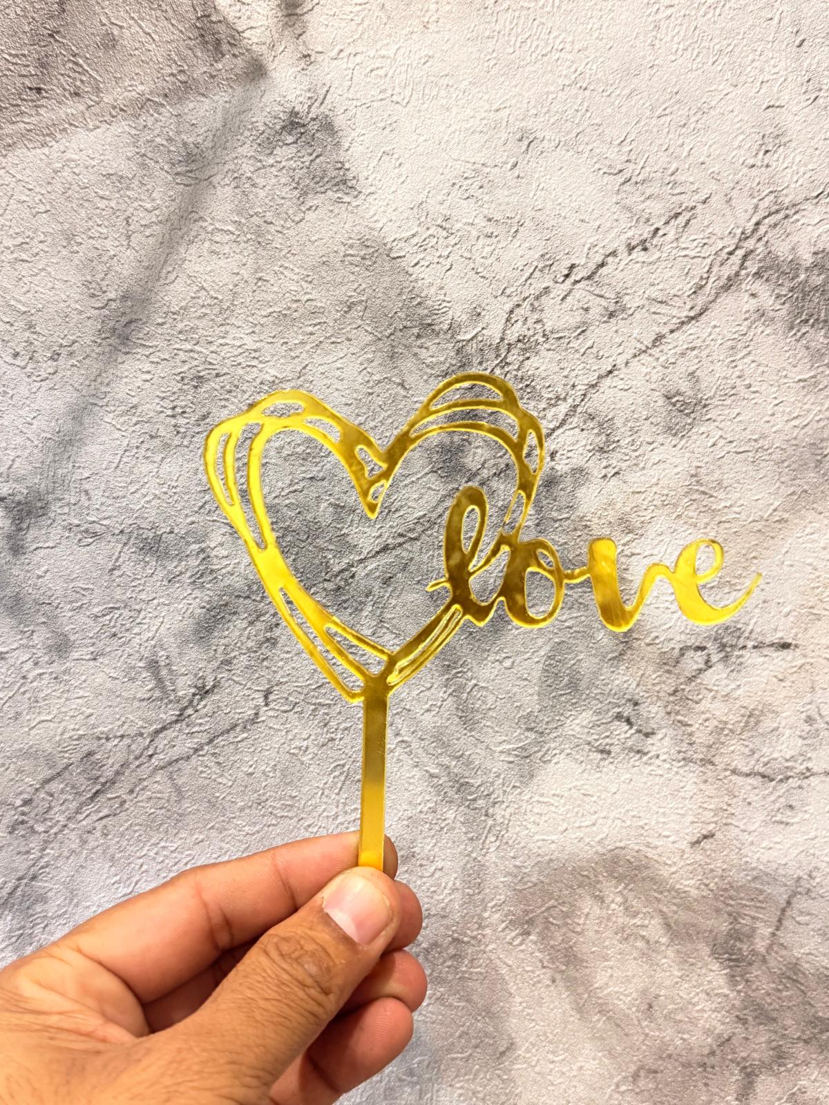 Gold Love Heart Cake Topper from Ward and Haneen, featuring a shiny metallic finish and elegant heart design for celebration cakes.