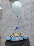 Deluxe chocolate gift box from Ward and Haneen with blue balloons, featuring assorted chocolates and elegant packaging.